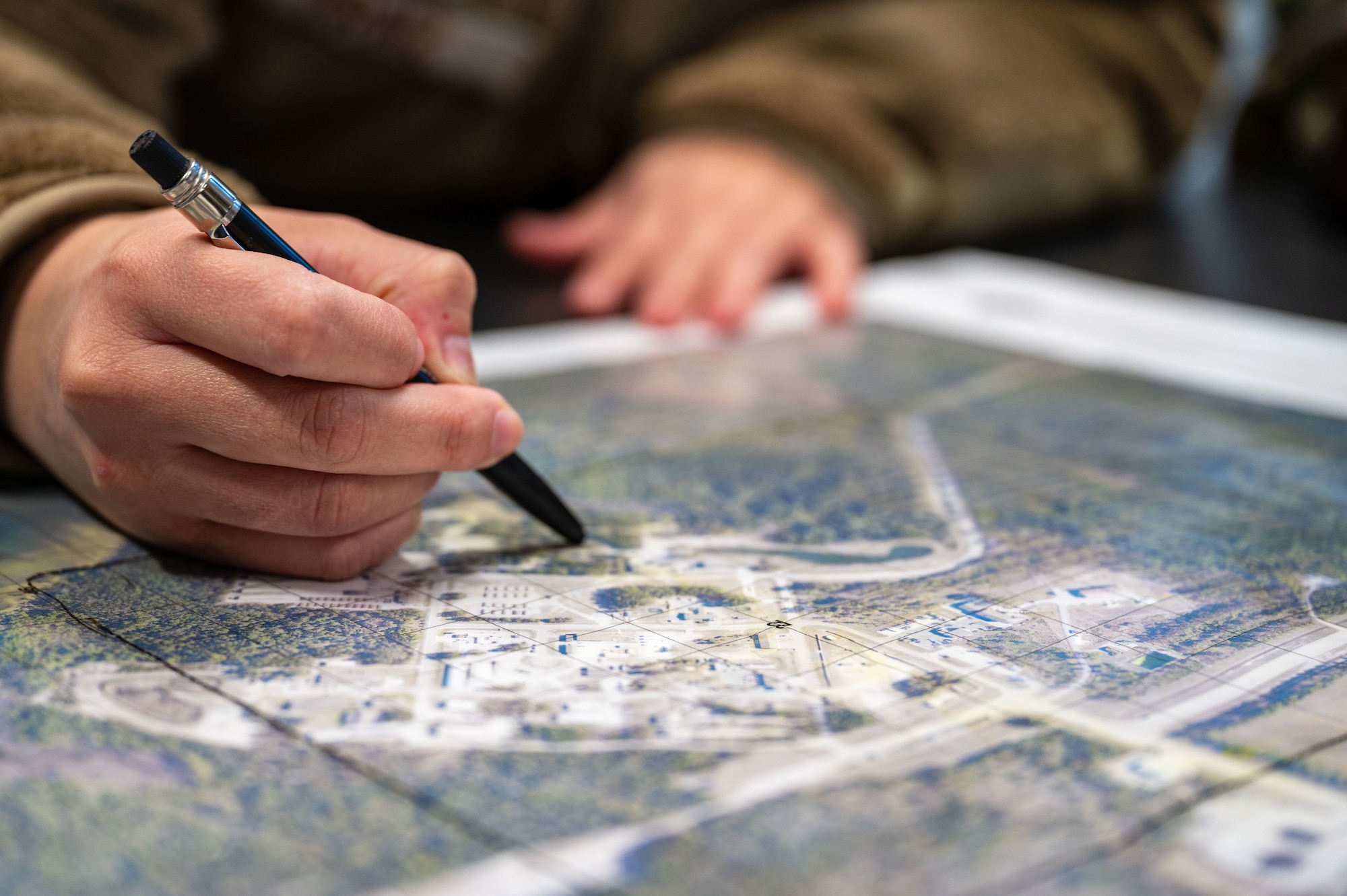 A U.S. Airman assigned to the 11th Air Task Force plots points on a map as part of personnel rescue and incident mitigation training at Tyndall Air Force Base, Florida, Jan. 23, 2025. Airmen were notified of a simulated downed aircraft and used a map to pinpoint the scene of the incident. (U.S. Air Force photo by Senior Airman Jasmyne Bridgers-Matos)