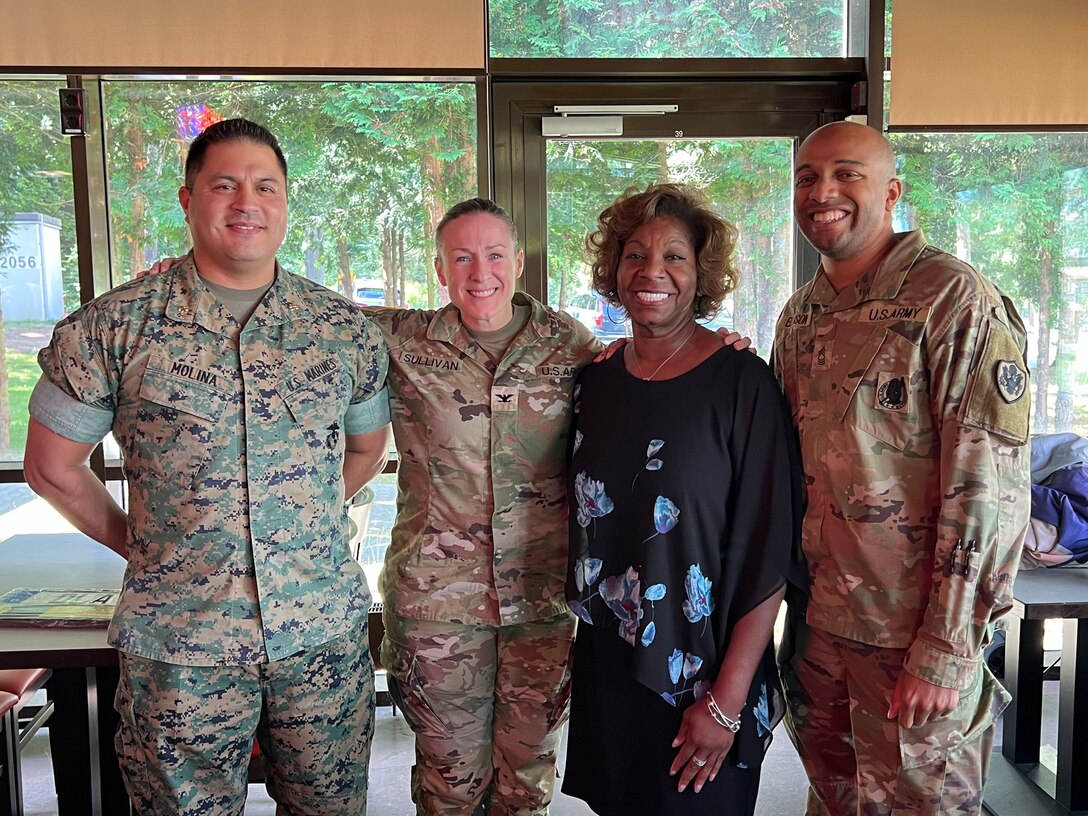 Four people pose for a group photo.