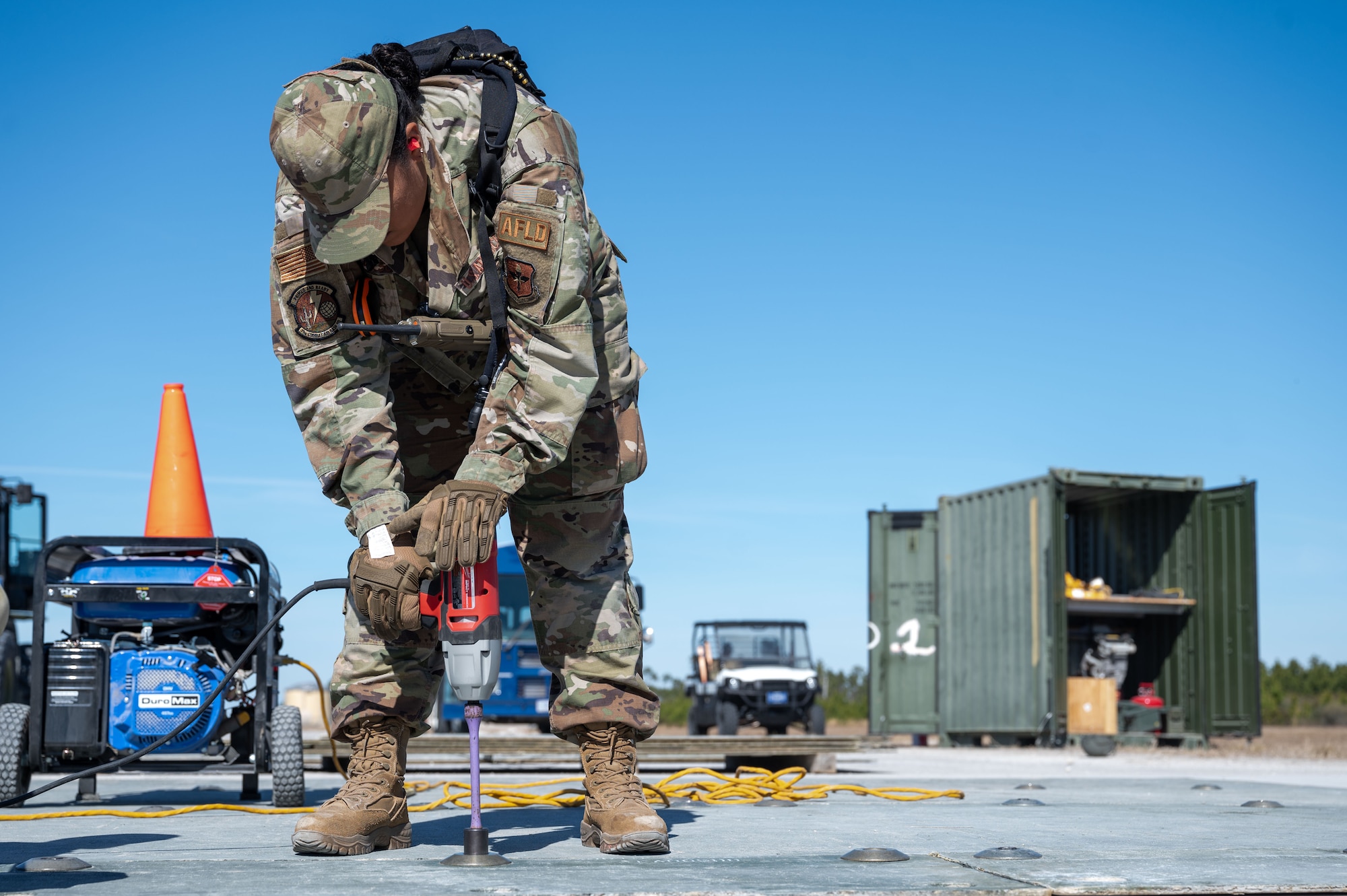 A U.S. Airman assigned to the 11th Air Task Force drills connections onto a fiberglass reinforced polymer at Tyndall Air Force Base, Florida, Jan. 26, 2025. Airmen constructed a temporary protective layer to cover a damaged section of the flight line and keep debris out of aircraft intake ports. (U.S. Air Force photo by Senior Airman Jasmyne Bridgers-Matos)