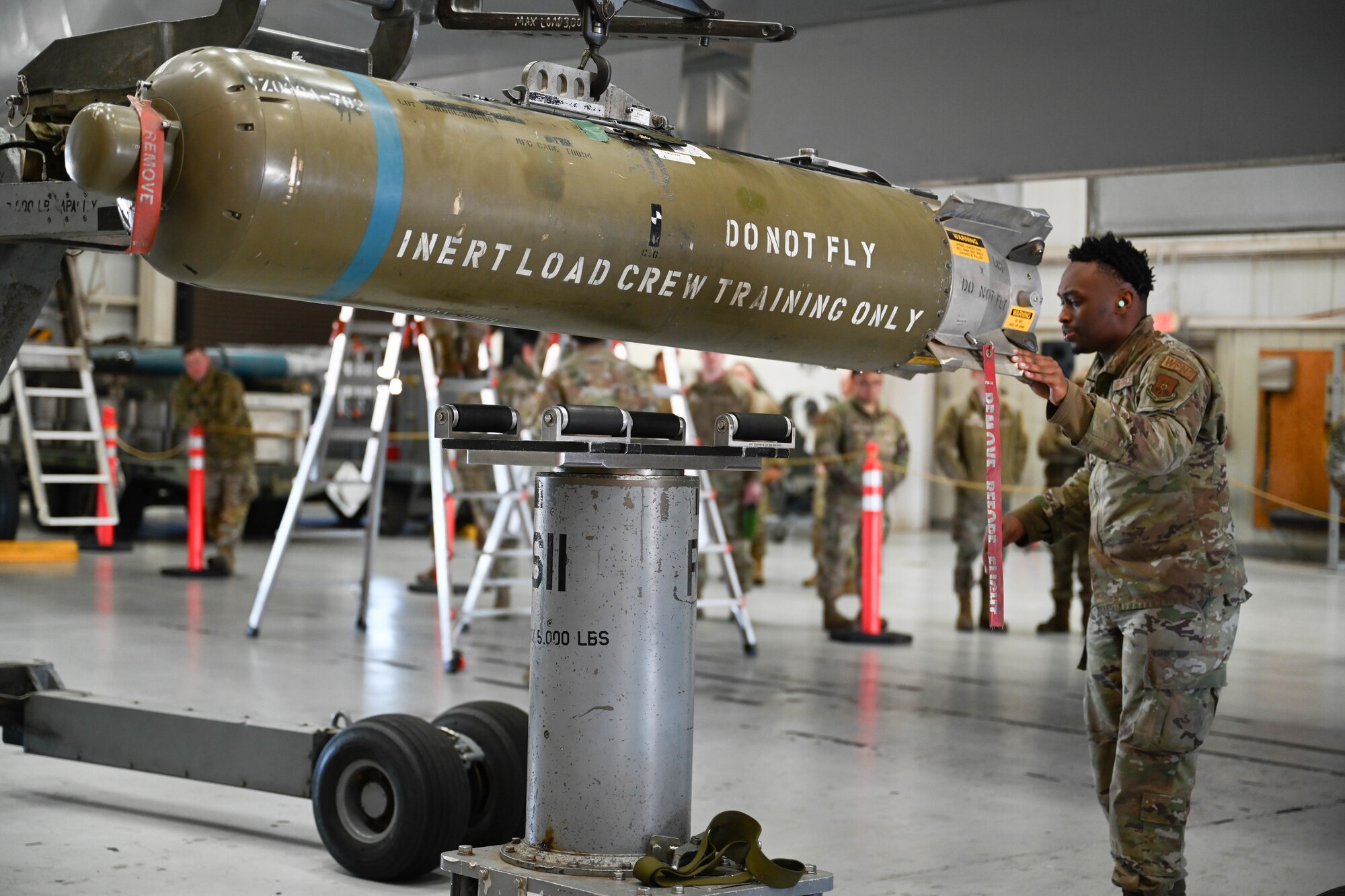 U.S. Air Force Airman 1st Class Tayveon Johnson, 9th Bomber Generation Squadron load crew member, prepares to load a cluster bomb unit, during the Lone Star Challenge, at Dyess Air Force Base, Texas, Jan. 24, 2025. Each BGS hand-selected a crew to compete against each other; the winner of the challenge will compete against other bases within Air Force Global Strike Command. (U.S. Air Force photo by Airman Caleb Schellenberg)