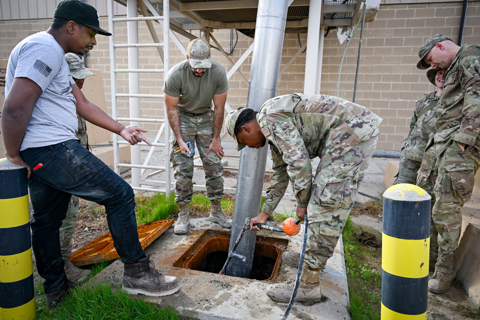 Six members look look at a hydro-excavation machine being used.