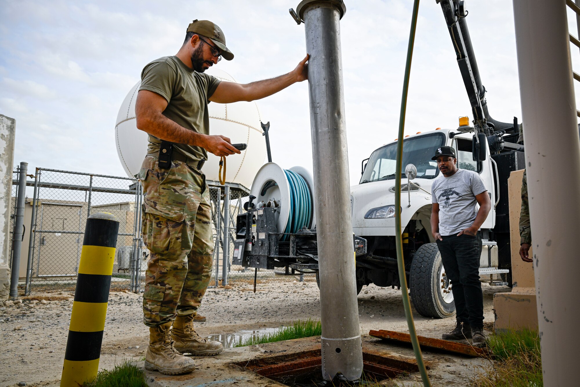 A U.S. Air Force Airman uses a hydro-excavation machine.