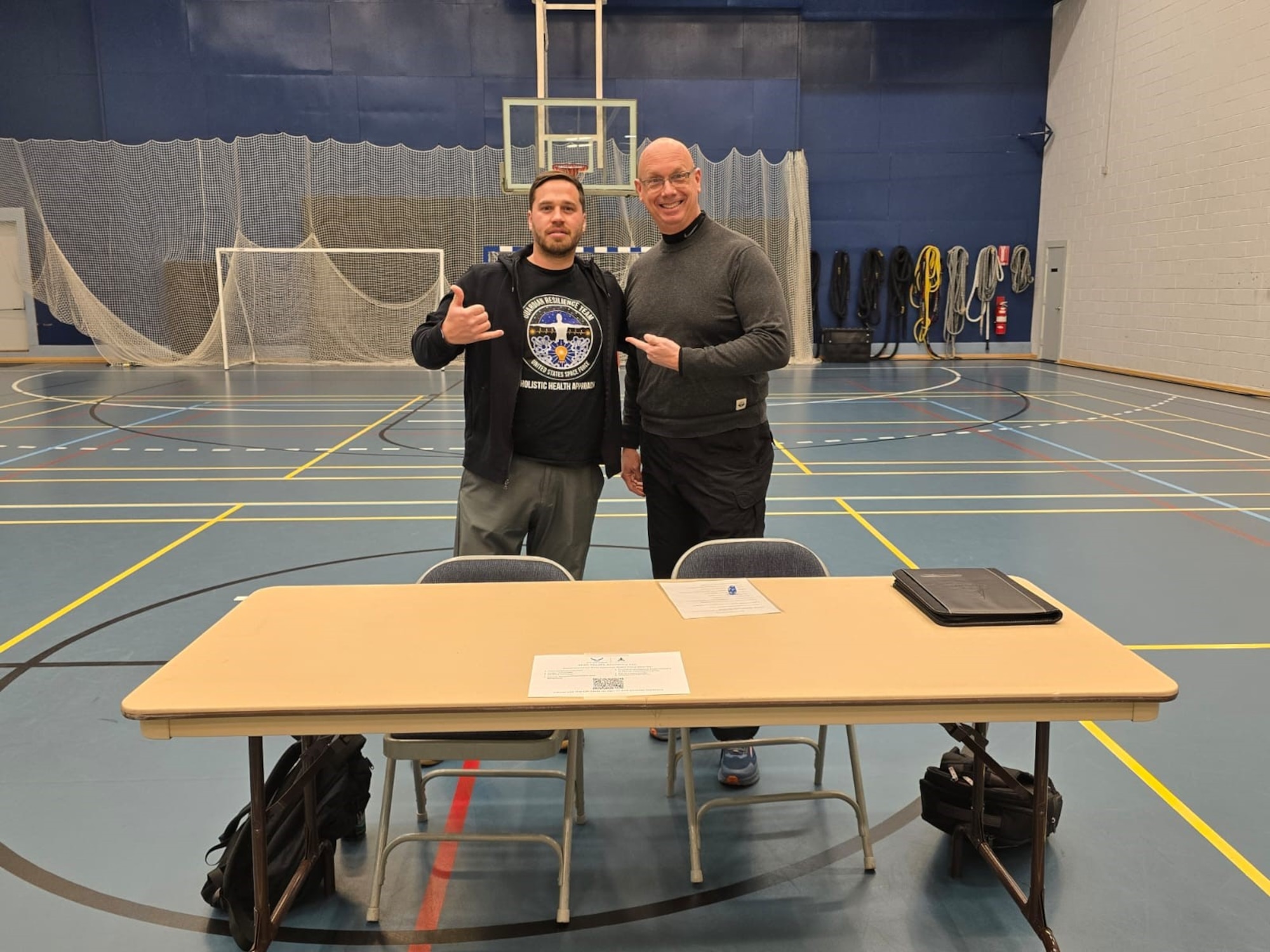 Members stand behind the desk posing for a photo at the resilience fair.