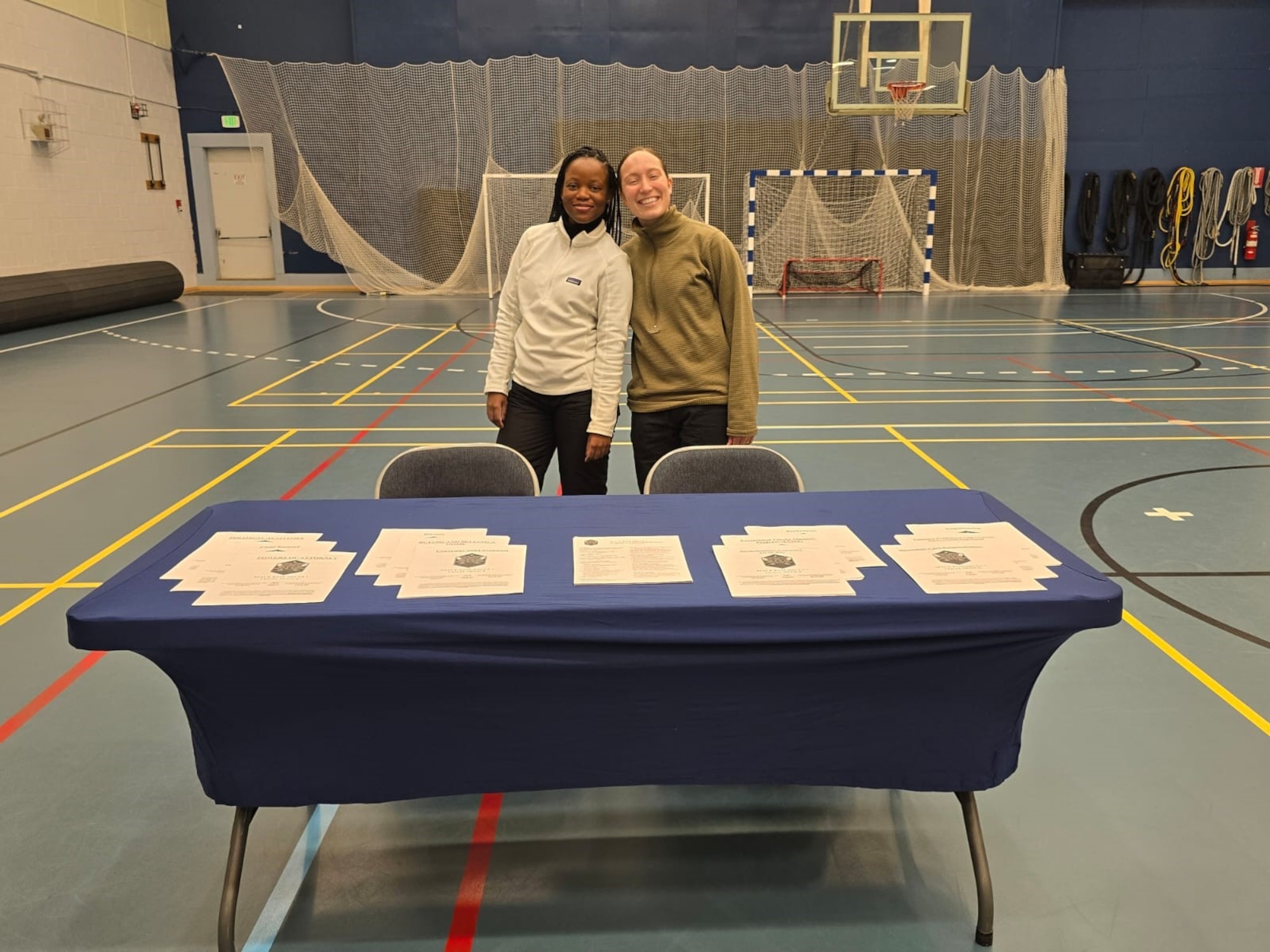 Both members stand behind a desk at the resilience fair.
