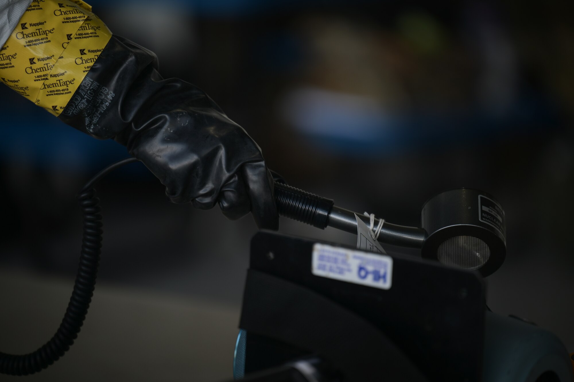 A gloved hand of an Airman holds chemical detection equipment.