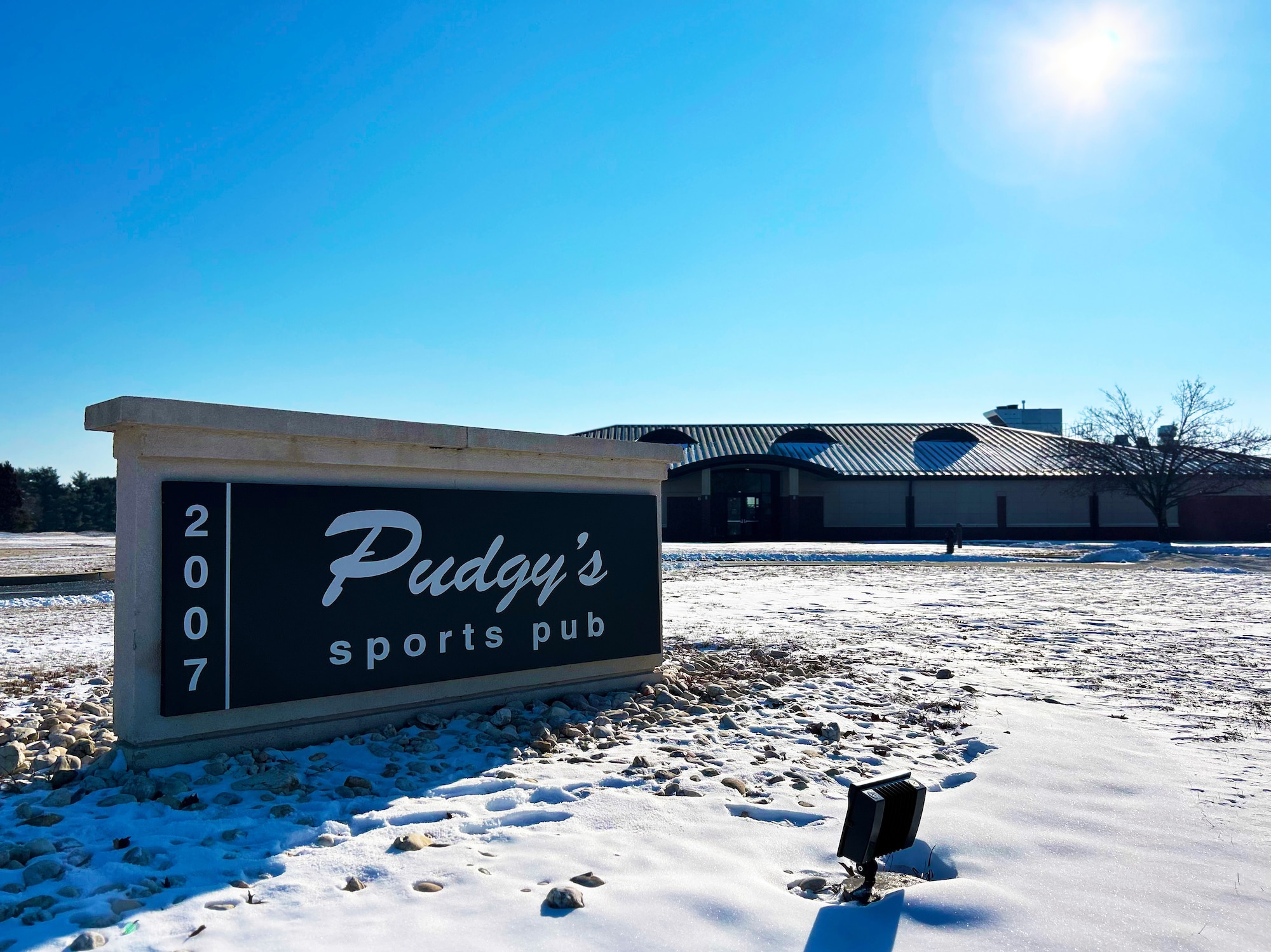 A sign is displayed in front of the new location for Pudgy’s Sport Pub at Joint Base McGuire-Dix-Lakehurst, N.J., Jan. 24, 2025. The original Pudgy’s, lovingly named for U.S. Air Force Maj. Thomas McGuire’s wife, Marilynn, opened on McGuire Air Force Base Sep. 27,1996. (U.S. Air Force photo by Jewaun McElroy)
