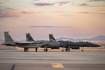 An F-15C Eagle (left) assigned to the 159th Fighter Wing, Louisiana Air National Guard, Naval Air Station Joint Reserve Base New Orleans, Louisiana, parks next to two F-15E Strike Eagles assigned to 366th Fighter Wing, Mountain Home Air Force Base (AFB), Idaho, taxi in after a mission during Red Flag-Nellis 25-1, Jan. 27, 2025, at Nellis AFB, Nevada.
