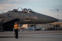 A U.S. Air Force Airman assigned to 366th Fighter Wing, Mountain Home Air Force Base (AFB), Idaho, salutes the aircrew of an F-15E Strike Eagle after a mission during Red Flag-Nellis 25-1, Jan. 27, 2025, at Nellis AFB, Nevada.