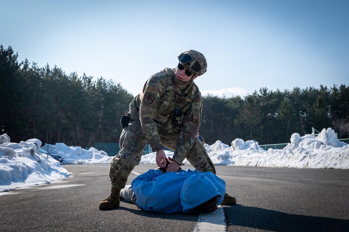 U.S. Air Force Senior Airman Devon Pena, 35th Security Force Squadron installation entry controller, grabs a simulated suspect's hands during an active shooter exercise at Misawa Air Base, Japan, Jan. 24, 2025. The 35th Fighter Wing prioritizes readiness, and exercises like these help Airmen sharpen their skills and prepare for any situation.