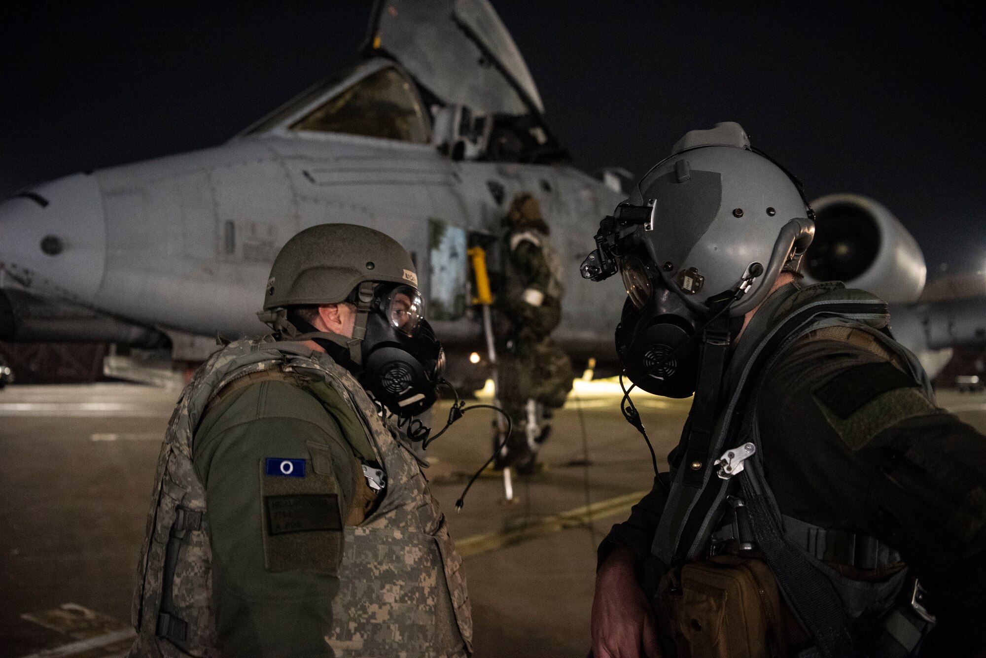 U.S. Air Force Capt. Chris Hidalgo, left, and Capt. Eric Fox, 25th Fighter Squadron A-10 Thunderbolt II pilots, conduct turnover during Beverly Herd 25-2 at Osan Air Base, Republic of Korea, Jan. 30, 2025. The two pilots exercised a rapid crew swap with simulated CBRN contamination as part of the exercise. (U.S. Air Force photo by Staff Sgt. Jason W. Cochran)