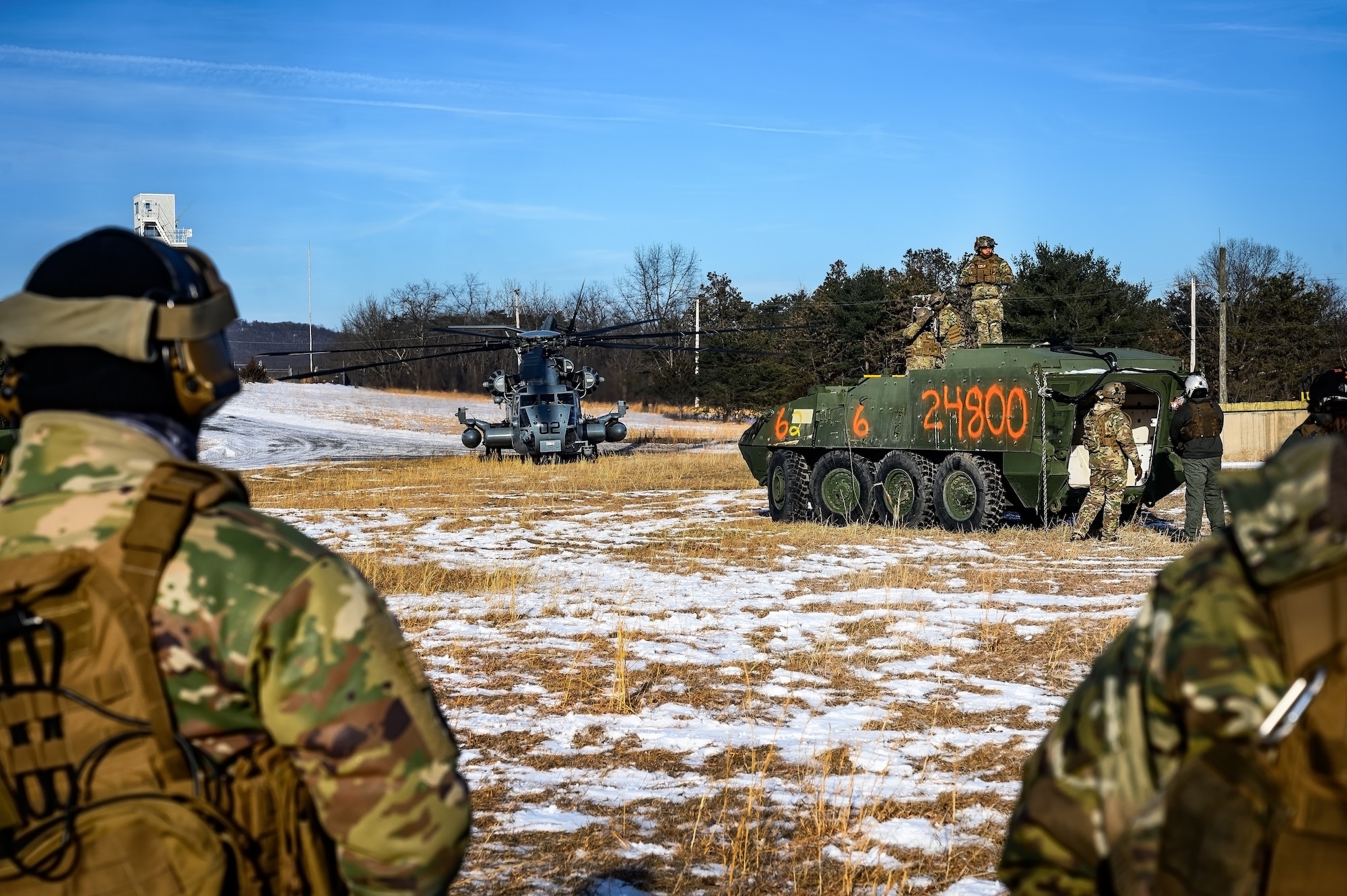 U.S. Air Force Airmen assigned to the 621st Contingency Response Group await to secure a Stryker heavy vehicle to a CH-53E Super Stallion helicopter assigned to Marine Heavy Helicopter Squadron 772 at Fort Indiantown Gap, P.A., Jan. 22, 2025. The 621st CRG was requested on behalf of the Pennsylvania Army National Guard to help lift and relocate nine Stryker armored vehicles to the Fort Indiantown Gap training range. The lift was assisted by a team of U.S. Air Force Airmen assigned to the 621st CRG who secured and released each Stryker to the helicopter. (U.S. Air Force photo by Senior Airman Matt Porter)