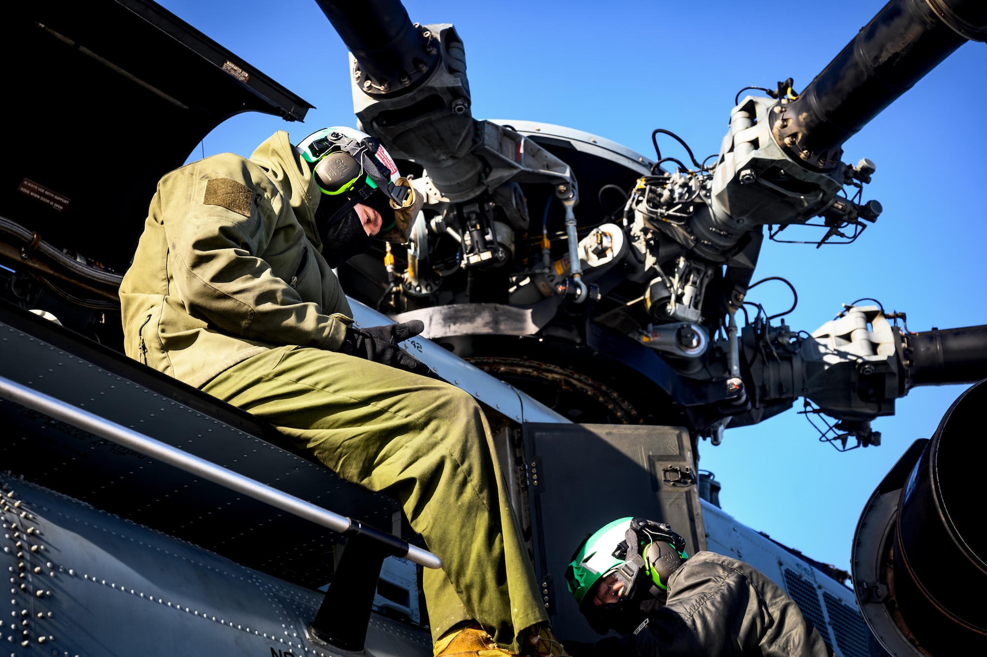U.S. Marine Corps Cpls. Ryan Ewing and Juan Estrada, Marine Heavy Helicopter Squadron 772 helicopter crew chiefs, perform a maintenance check on a CH-53E Super Stallion helicopter for takeoff at Joint Base McGuire-Dix-Lakehurst, N.J., Jan. 22, 2025. The helicopter was requested on behalf of the Pennsylvania Army National Guard to lift and relocate nine Stryker armored vehicles to the Fort Indiantown Gap training range. The lift was assisted by a team of U.S. Air Force Airmen assigned to the 621st Contingency Response Group who secured and released each Stryker to the helicopter. (U.S. Air Force photo by Senior Airman Matt Porter)
