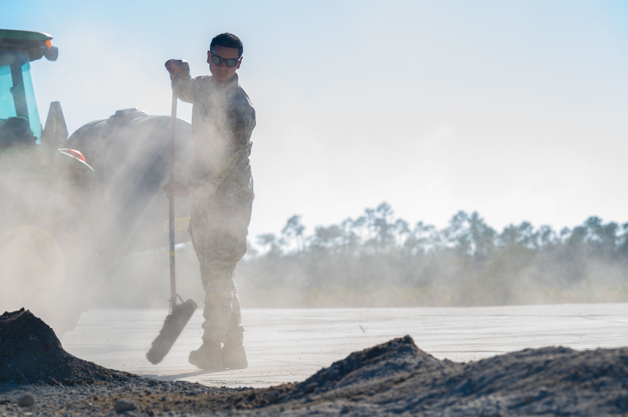 A U.S. Airman assigned to the 11th Air Task Force clears debris off the flight line at Tyndall Air Force Base, Florida, Jan. 26, 2025. Airmen removed debris to maintain their working area while performing a crater repair. (U.S. Air Force photo by Senior Airman Jasmyne Bridgers-Matos)