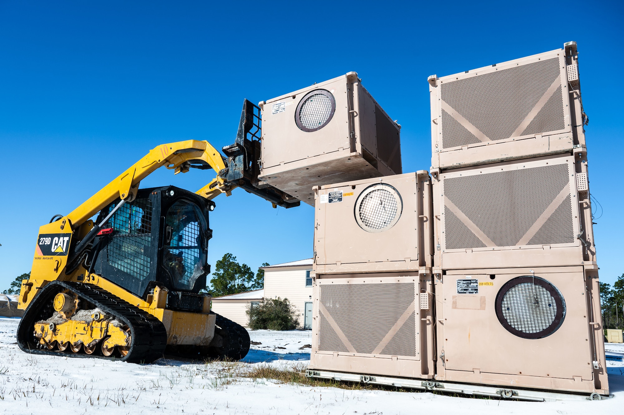 A U.S. Airman assigned to the 11th Air Task Force uses a compact track loader vehicle to move a heating, ventilation and air conditioning unit at Tyndall Air Force Base, Florida, Jan. 22, 2025. Civil engineer Airmen maintained the infrastructure and utilities that support combat operations. (U.S. Air Force photo by Senior Airman Jasmyne Bridgers-Matos)
