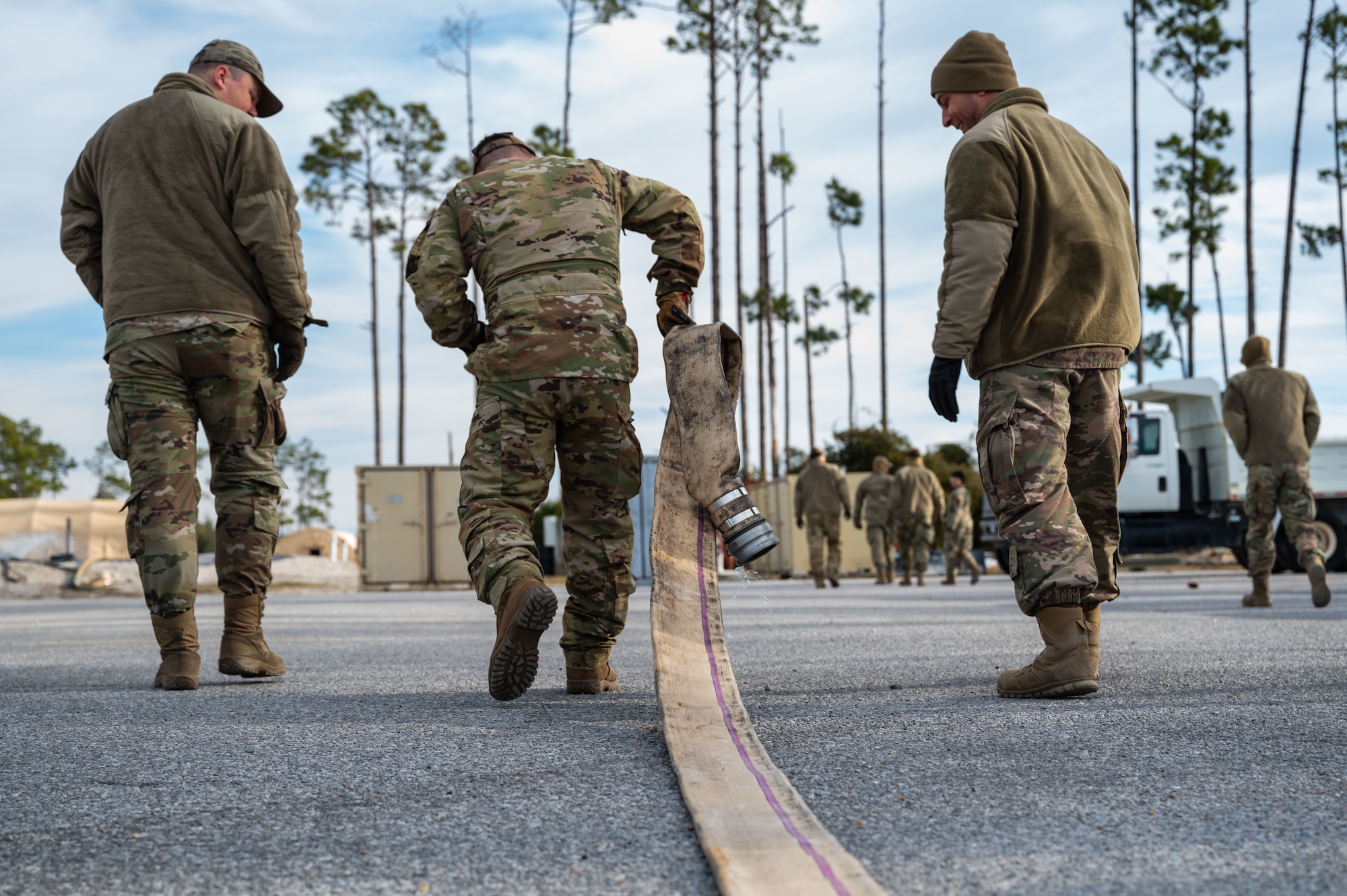 A U.S. Airman assigned to the 11th Air Task Force unravels a hose to establish a water supply at Tyndall Air Force Base, Florida, Jan. 21, 2025. Connecting water sources allowed for proper transfer and monitoring of the water supply. (U.S. Air Force photo by Senior Airman Jasmyne Bridgers-Matos)