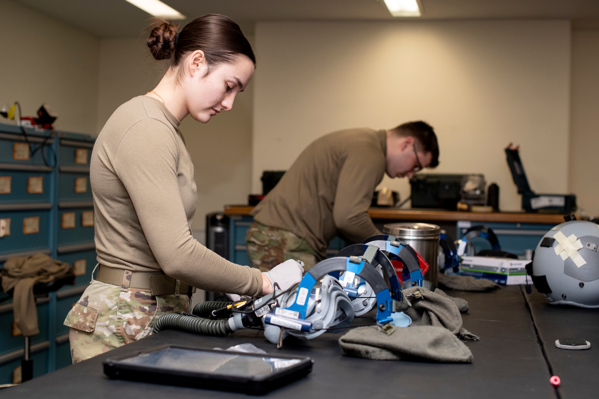Airmen inspects a folding quick don mask.