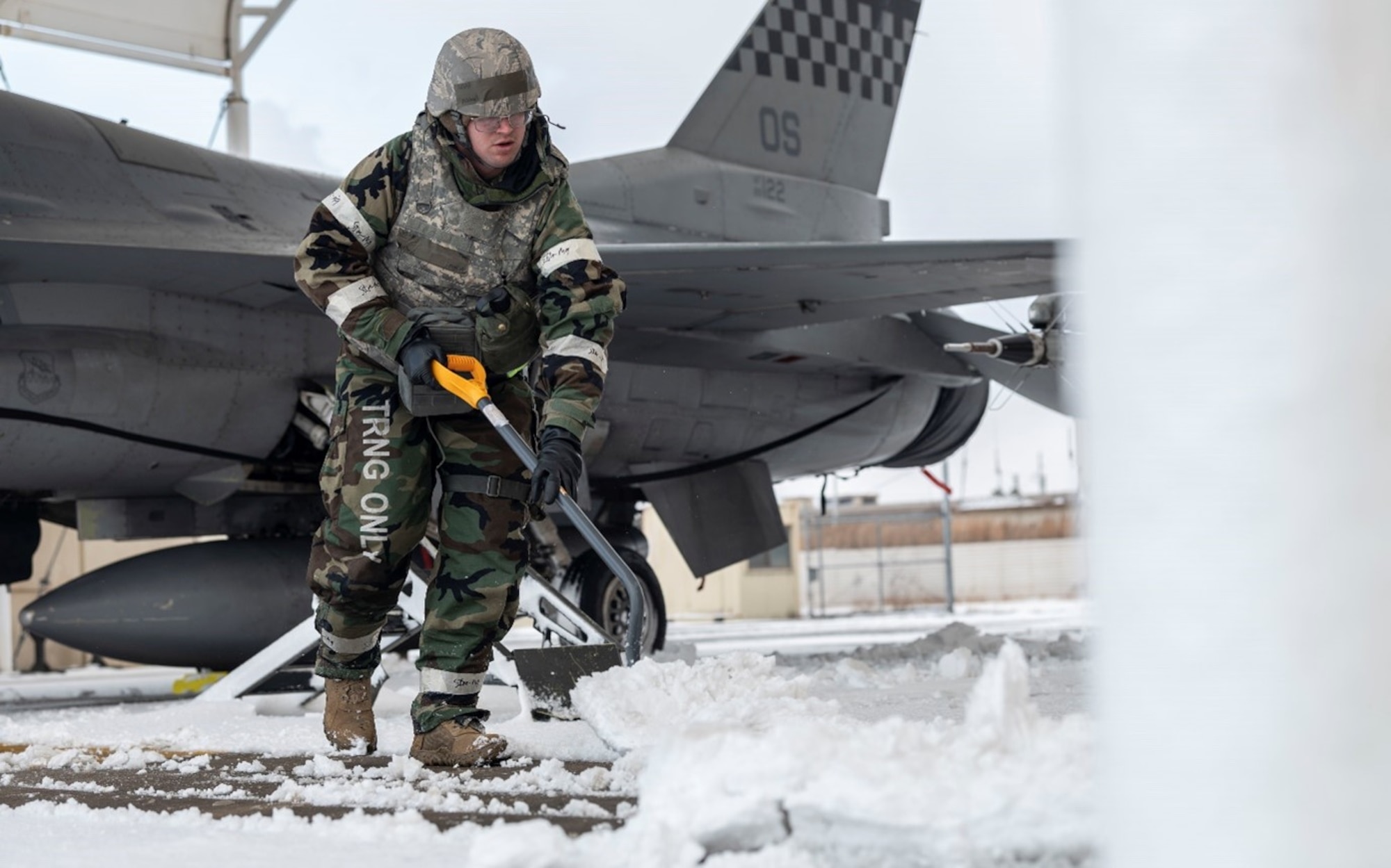 U.S. Air Force Tech. Sgt. Michael English, 51st Mission Support Group petroleum, oil and lubricant technician, shovels snow around an F-16 Fighting Falcon at Kunsan Air Base, Republic of Korea, Jan. 28, 2025. Members had to get hands on for snow removal during exercise Beverly Herd 25-2 due to limited resources. These kinds of solutions are a large part of practicing agile combat employment capabilities and generating airpower from alternate locations. (U.S. Air Force photo by Staff Sgt. Ashley N. Mikaio)