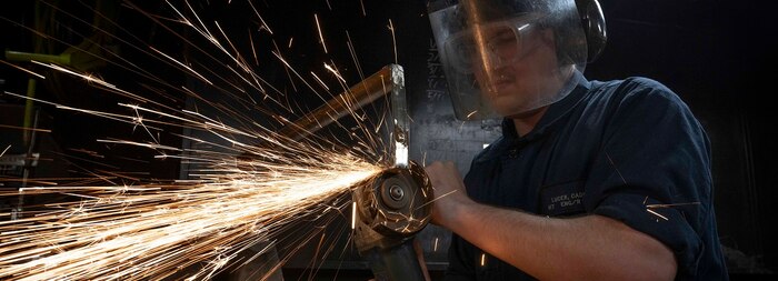 Hull Maintenance Technician Fireman Caden Lucek, from Cottage Grove, Oregon, grinds scrap metal aboard the aircraft carrier USS Nimitz (CVN 68) in the Pacific Ocean, Jan. 27, 2025.