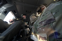 Looking up inside a UH-72 Lakota helicopter at a U.S. Border Patrol agent and California National Guard Soldier.