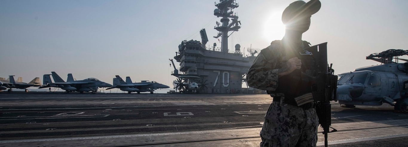 Master-at-Arms 1st Class Justin Genova, of Burbank, Calif., stands watch on the flight deck of the Nimitz-class aircraft carrier USS Carl Vinson (CVN 70) as the ship gets underway in Laem Chabang, Thailand, Jan. 31, 2025.