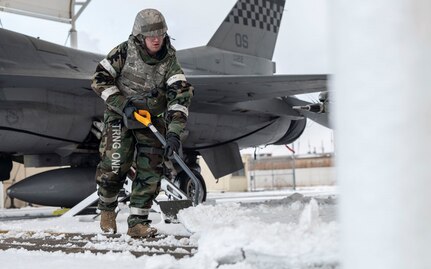 U.S. Air Force Tech. Sgt. Michael English, 51st Mission Support Group petroleum, oil and lubricant technician, shovels snow around an F-16 Fighting Falcon at Kunsan Air Base, Republic of Korea, Jan. 28, 2025. Members had to get hands on for snow removal during exercise Beverly Herd 25-2 due to limited resources. These kinds of solutions are a large part of practicing agile combat employment capabilities and generating airpower from alternate locations. (U.S. Air Force photo by Staff Sgt. Ashley N. Mikaio)