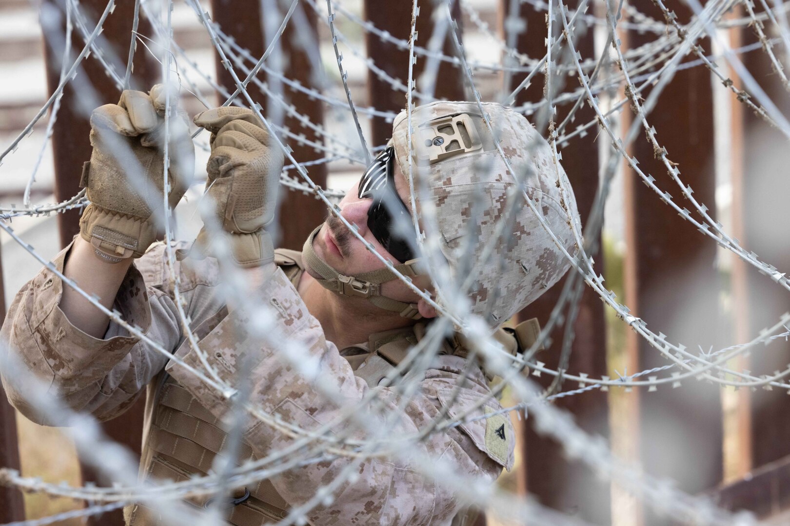 A Marine secures wired fencing.