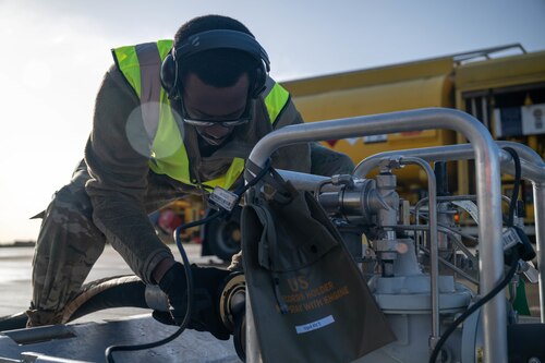 Crew chief attaches fuel hose to kit.