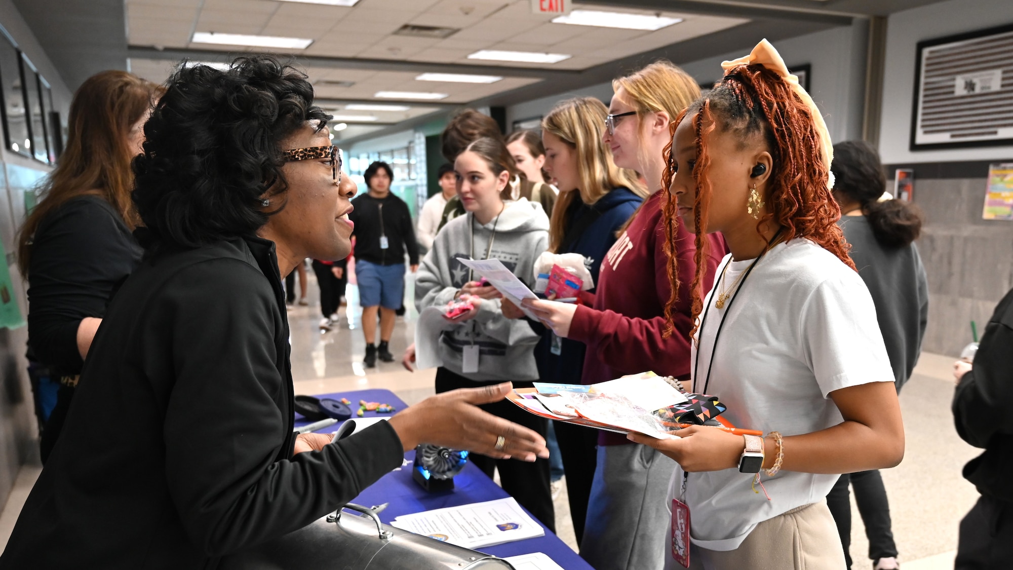 two women speaking to young students