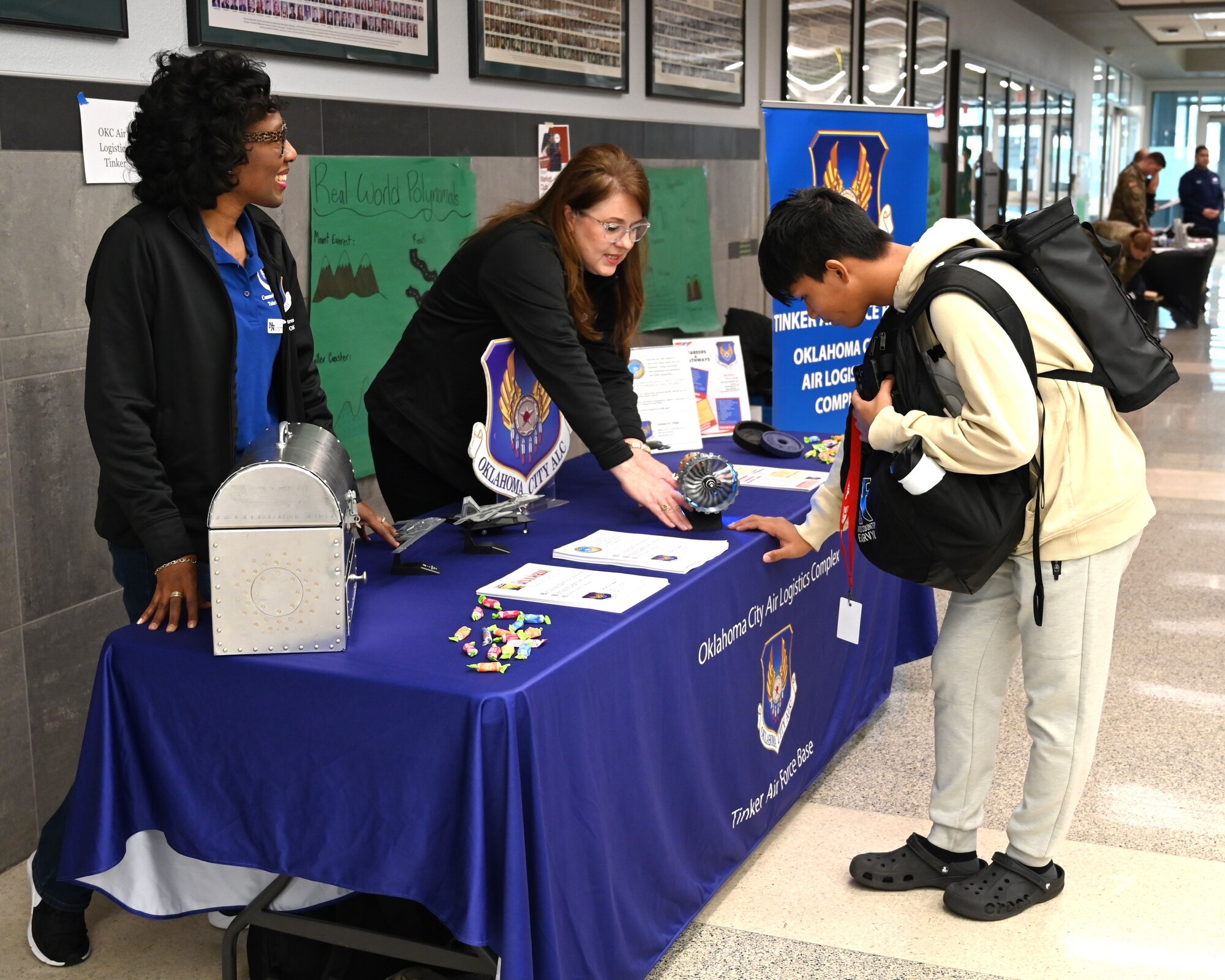 two women talks to a male student