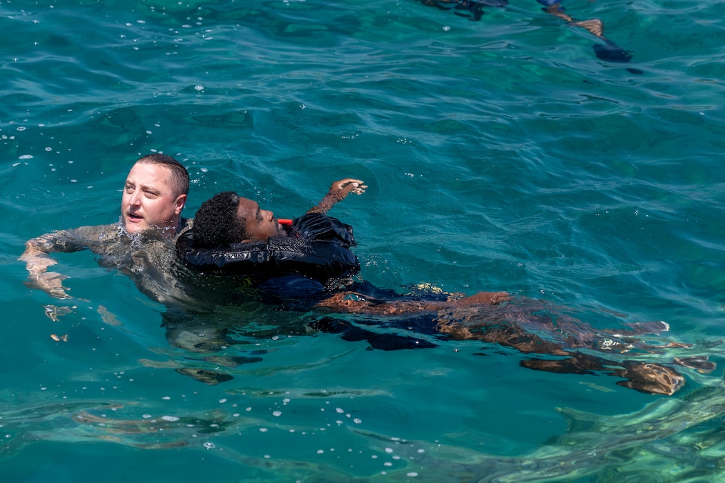 Master Sgt. Michael Muschong, assigned to Detachment 1, 95th Reconnaissance Squadron, carries Machinist Mate 2nd Class Corliss Rodgers, assigned to Naval Support Activity Souda Bay, as they learn rescue swimming basics during Sword and Shield, a leadership, training, and camaraderie exercise hosted by NATO Maritime Interdiction Operational Training Centre at the NATO Marathi Pier Complex in Souda Bay, Greece, on June 18, 2025.