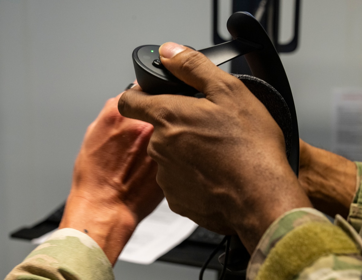 U.S. Air Force Senior Airman Jacob Rigby, left, 39th Operations Support Squadron air traffic control trainer, demonstrates virtual reality simulator controls to Brandon Johnson-Farmer, 39th OSS senior watch supervisor, at Incirlik Air Base, Türkiye, June 30, 2025.