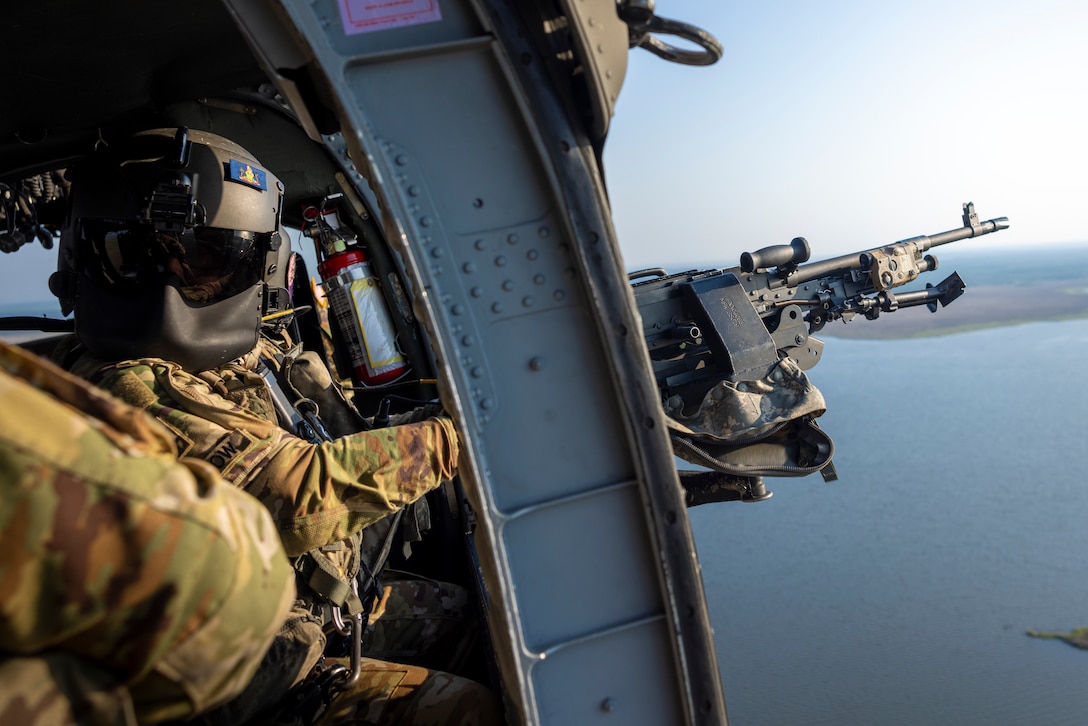 A U.S. Soldier assigned to the 2-104th General Support Aviation Battalion, 28th Expeditionary Combat Aviation Brigade, Pennsylvania Army National Guard, prepares to fire an M240B machine gun during a live-fire door gunner exercise near Bombing Target 11, North Carolina, June 23, 2025.