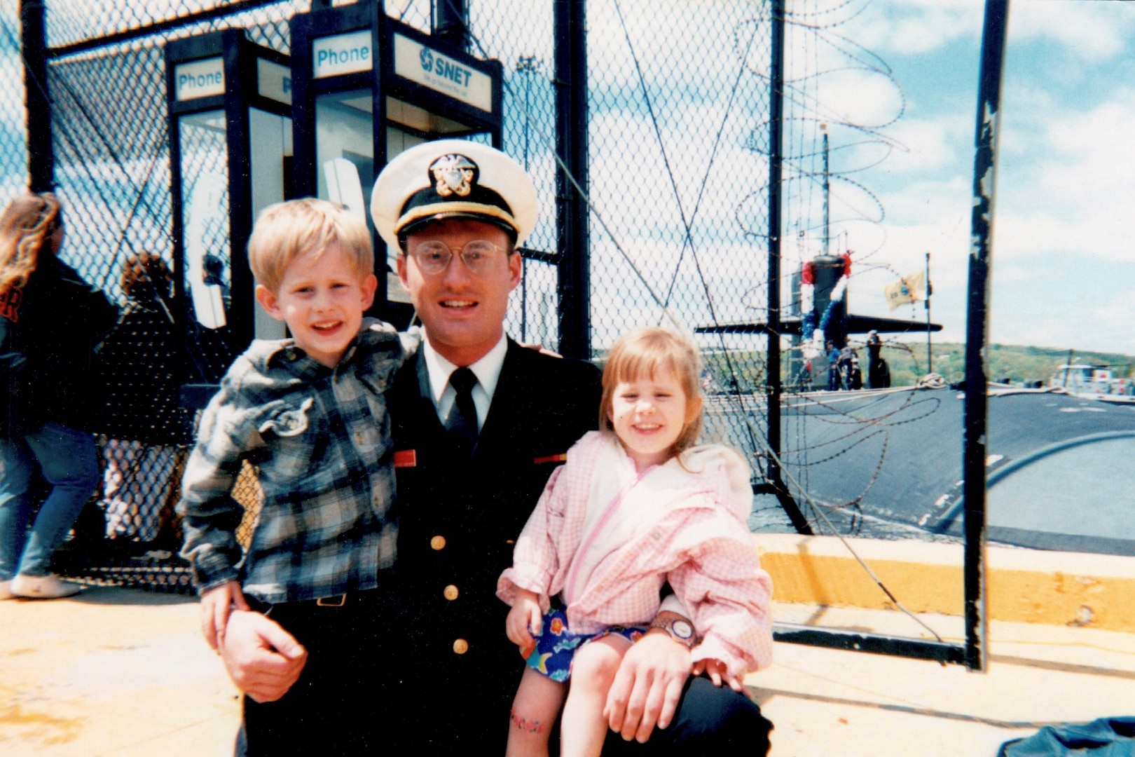 Wyatt J. Nash, Underwater Electromagnetics Stealth Advisor at Naval Surface Warfare Center Carderock Division, stands on the pier with his children after returning from his first submarine deployment in 1996. Nash is one of 10 recipients of the 2025 Assistant Secretary of the Navy (Research, Development and Acquisition) Dr. Delores M. Etter Top Scientists and Engineers of the Year Award. Carderock, the Navy's ship design and innovation powerhouse, provides the technical foundation for the future fleet through world-class research, development, and testing. (Photo courtesy of Wyatt J. Nash)