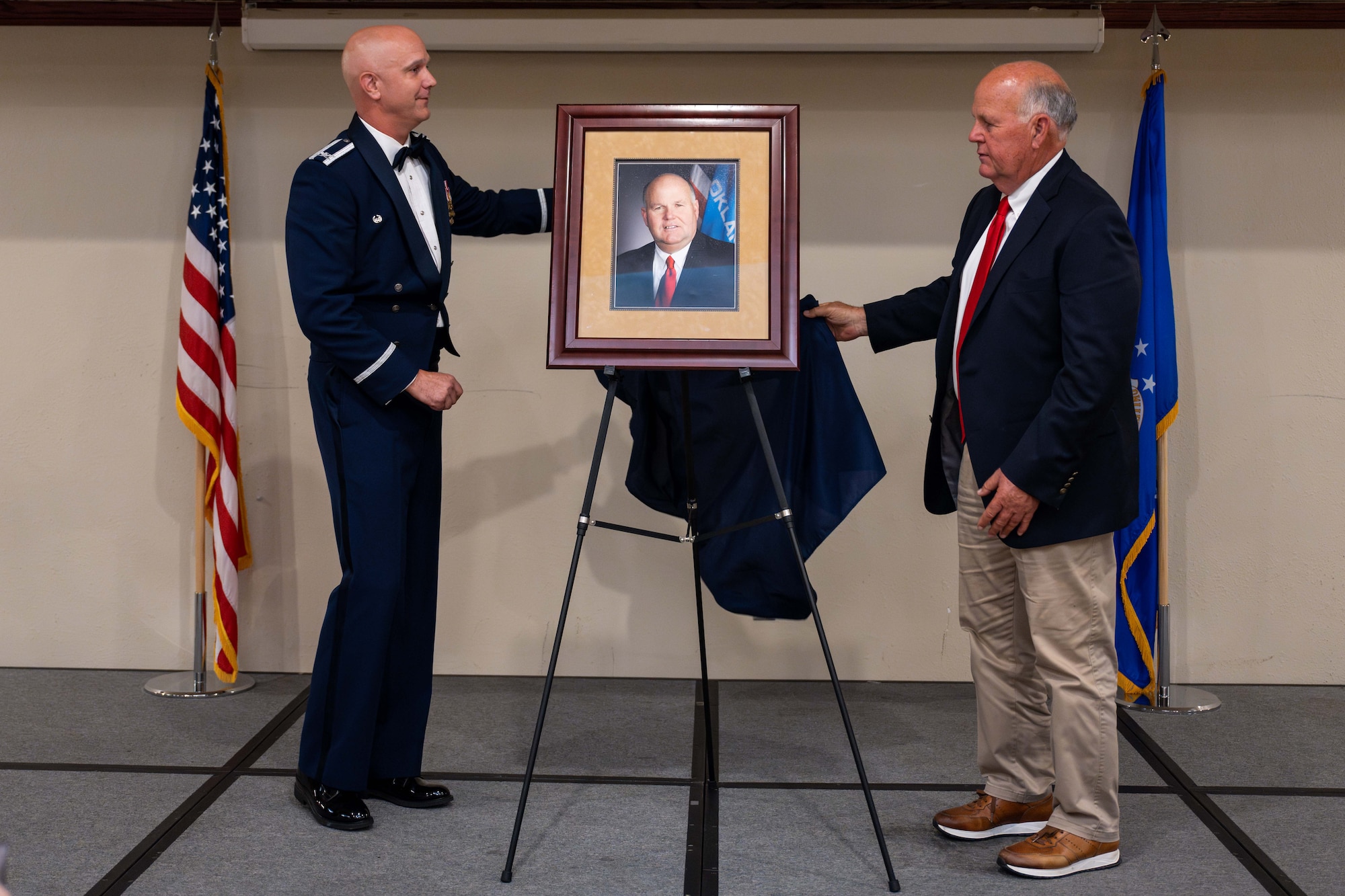 U.S. Air Force Col. Jeff Marshall, 97th Air Mobility Wing commander, and Gary Jones, Altus city manager, unveil Jones’s portrait during the Friends of Altus Induction Ceremony, June 26, 2025, at Altus Air Force Base, Oklahoma. Jones has decades of public service experience and is the longest-serving city manager since Altus adopted its current form of government. (U.S. Air Force Photo by Airman 1st Class Jonah Bliss)