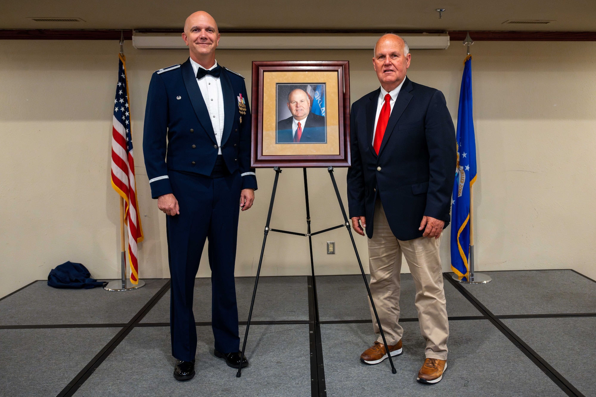 U.S. Air Force Col. Jeff Marshall, 97th Air Mobility Wing (AMW) commander, and Gary Jones, Altus city manager, stand with Jones’s portrait during the Friends of Altus Induction Ceremony, June 26, 2025, at Altus Air Force Base, Oklahoma. To be named a Friend of Altus is the highest honor a local civilian can receive from a 97th AMW Commander. (U.S. Air Force Photo by Airman 1st Class Jonah Bliss)