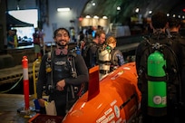Charlie Giglio, a rising senior and student trainee at Naval Surface Warfare Center, Carderock Division, poses by his submarine, Exilenni, during the 18th International Submarine Races (ISR 18), hosted at Carderock from June 23-27, 2025. He served as both a support diver and the lead structures engineer for the Virginia Tech human-powered submarine team at ISR18. Carderock, the Navy's ship design and innovation powerhouse, provides the technical foundation for the future fleet through world-class research, development, and testing. (U.S. Navy photo by Travis Troller)