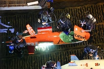 Divers and team members from Virginia Tech make in-water adjustments to their submarine, Exlienni, during a race cycle at the 18th International Submarine Races (ISR 18), hosted at Naval Surface Warfare Center, Carderock Division, from June 23-27, 2025. Carderock, the Navy's ship design and innovation powerhouse, provides the technical foundation for the future fleet through world-class research, development, and testing. (U.S. Navy photo by Kristin Behrle)