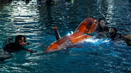 Virginia Tech team members Charlie Giglio and Maggie Campbell prepare their human-powered submarine, Exlienni, during a dive cycle at the 18th International Submarine Races (ISR 18), hosted at Naval Surface Warfare Center, Carderock Division from June 23-27, 2025. Both students served as support divers in addition to their engineering roles. Carderock, the Navy's ship design and innovation powerhouse, provides the technical foundation for the future fleet through world-class research, development, and testing. (U.S. Navy photo by Corum Beyers)