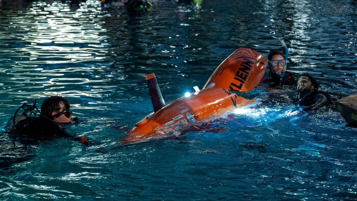 Virginia Tech team members Charlie Giglio and Maggie Campbell prepare their human-powered submarine, Exlienni, during a dive cycle at the 18th International Submarine Races (ISR 18), hosted at Naval Surface Warfare Center, Carderock Division from June 23-27, 2025. Both students served as support divers in addition to their engineering roles. Carderock, the Navy's ship design and innovation powerhouse, provides the technical foundation for the future fleet through world-class research, development, and testing. (U.S. Navy photo by Corum Beyers)