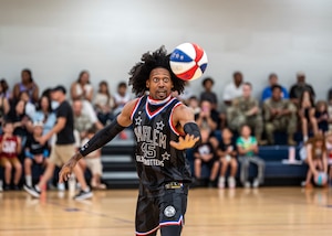 Harlem Globetrotter “Moose” Weekes performs a basketball handling trick at Moody Air Force Base, Georgia, June 26, 2025. With a legacy spanning nearly a century, the Globetrotters bring entertainment and inspiration to fans of all ages. (U.S. Air Force photo by Senior Airman Leonid Soubbotine)