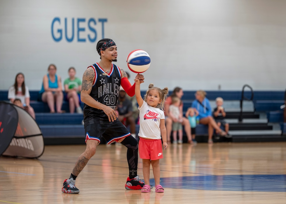 Harlem Globetrotter “Wham” Middleton performs basketball handling tricks at Moody Air Force Base, Georgia, June 26, 2025. With a legacy spanning nearly a century, the Globetrotters bring entertainment and inspiration to fans of all ages. (U.S. Air Force photo by Senior Airman Leonid Soubbotine)