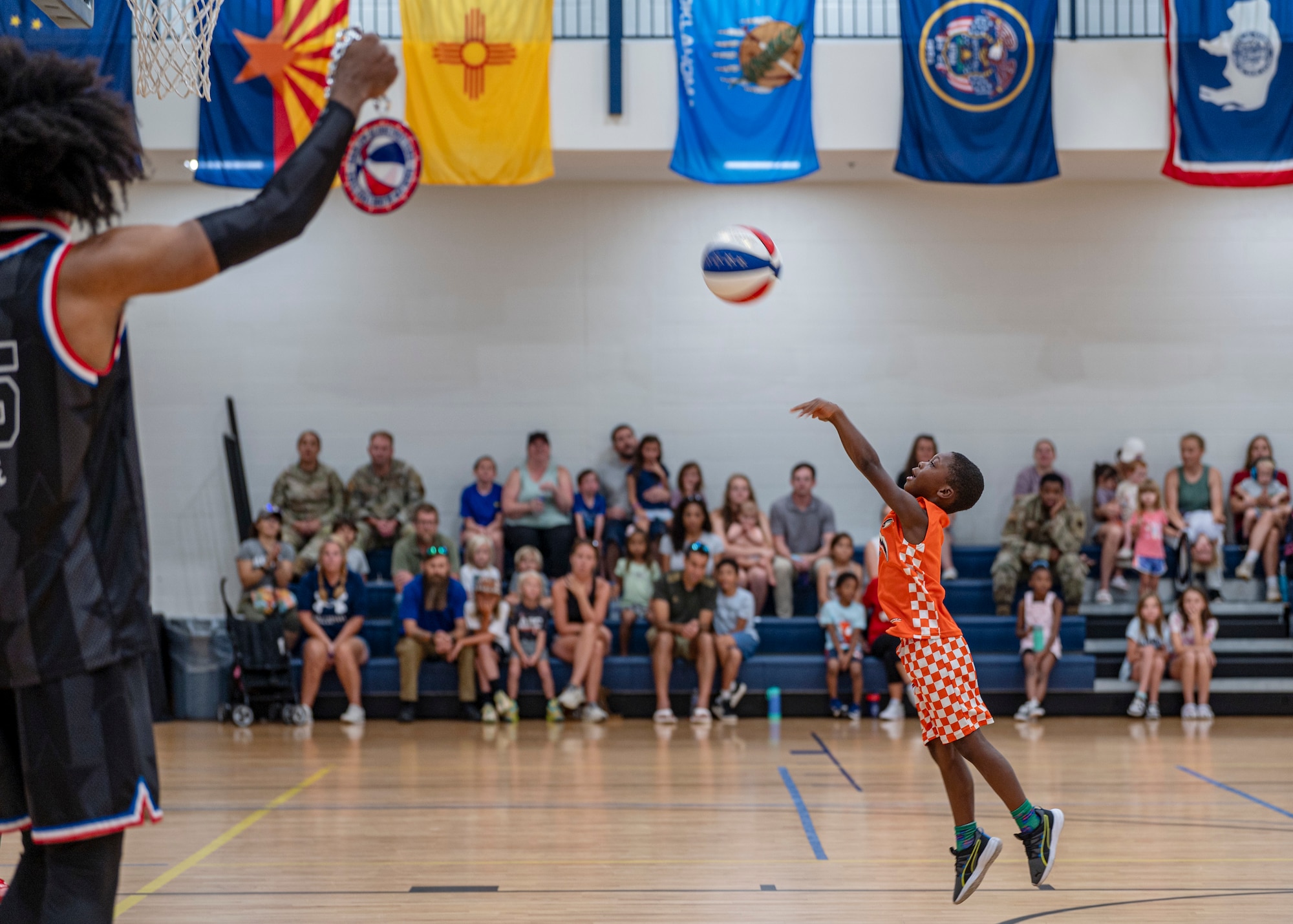 A young participant shoots a basketball during a Harlem Globetrotters visit at Moody Air Force Base, Georgia, June 26, 2025. The Harlem Globetrotters frequently visit military bases worldwide, bringing entertainment and support to service members and their families. (U.S. Air Force photo by Senior Airman Leonid Soubbotine)