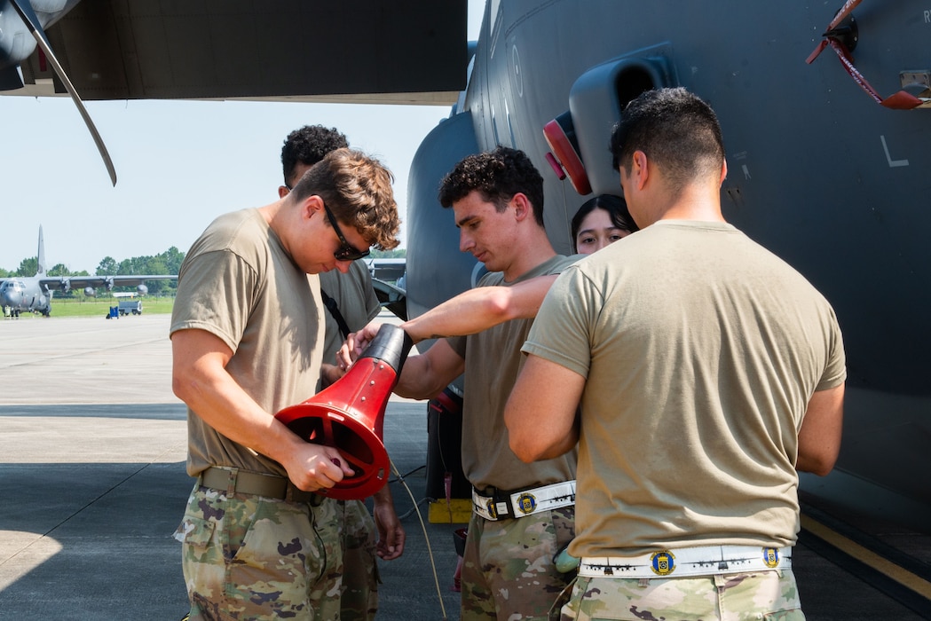 Group of airmen working on a plane outside.