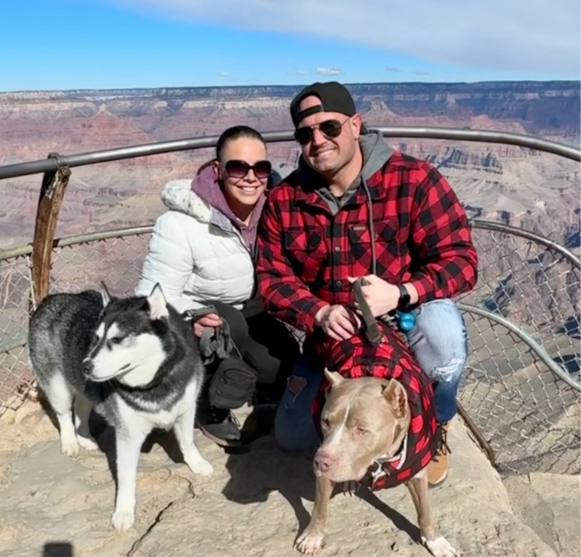 Man and woman pose with two dogs