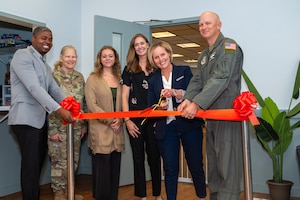 Wing commander and his wife cut a ribbon at an opening ceremony