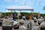 Airmen sitting in chairs during a ceremony.