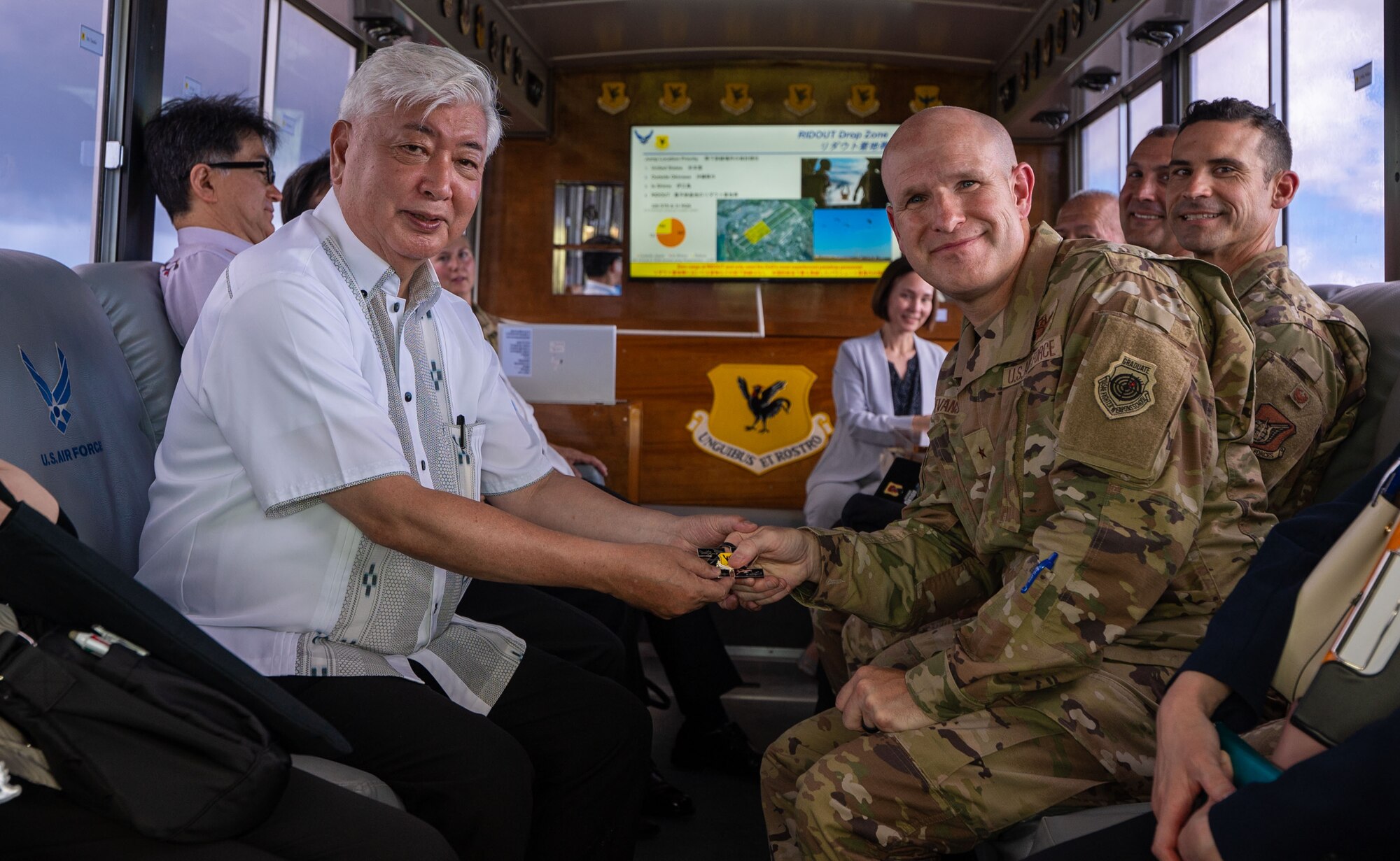 U.S. Air Force Brig. Gen. Nicholas Evans, right, 18th Wing commander, gifts a coin to Honorable Gen Nakatani, Japan's Minister of Defense, during Nakatani’s visit to Kadena Air Base, Japan, June 23, 2025.