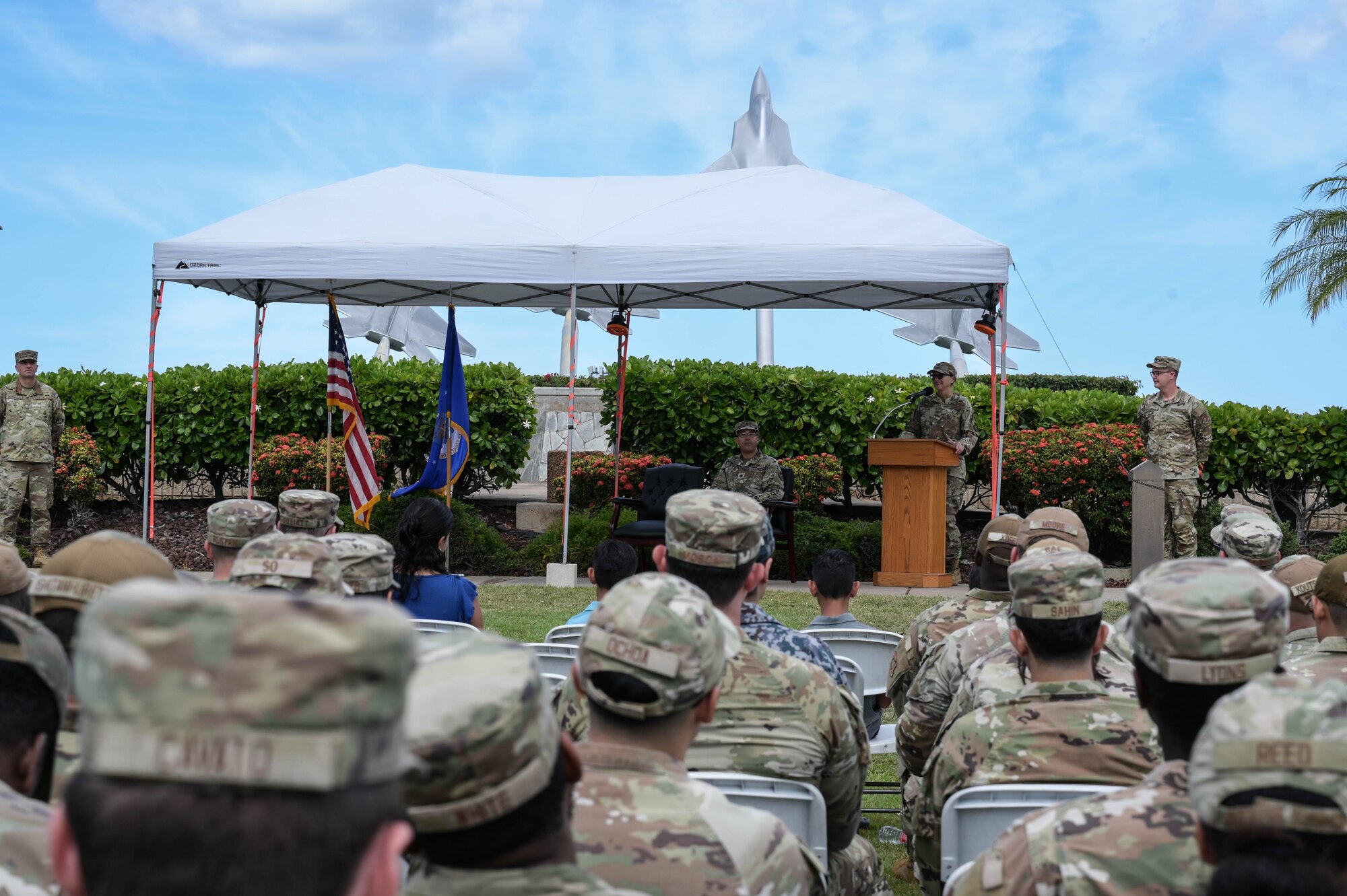 Airmen sitting in chairs during a ceremony.