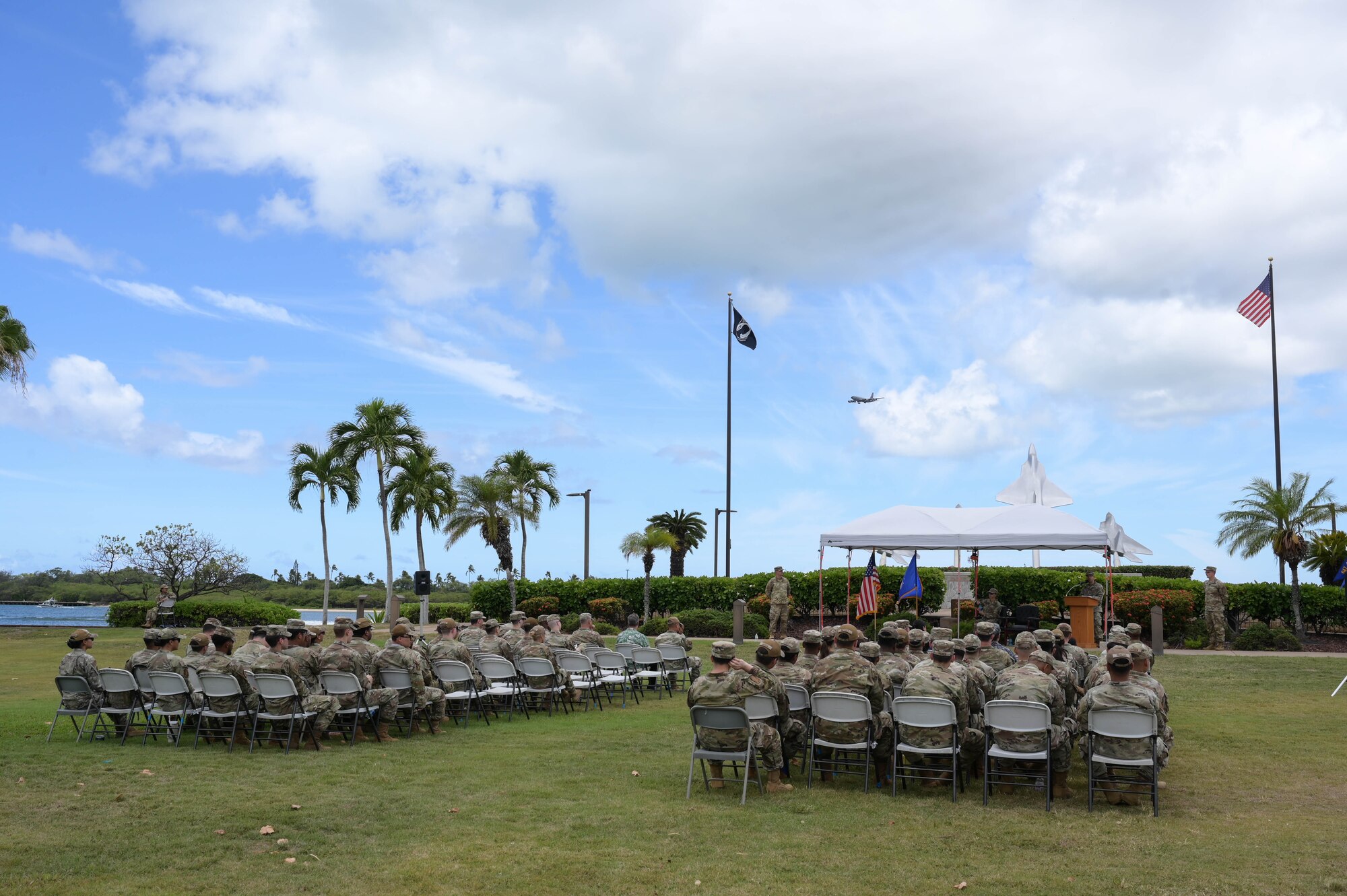 Photo of Airmen sitting in chairs at a ceremony.
