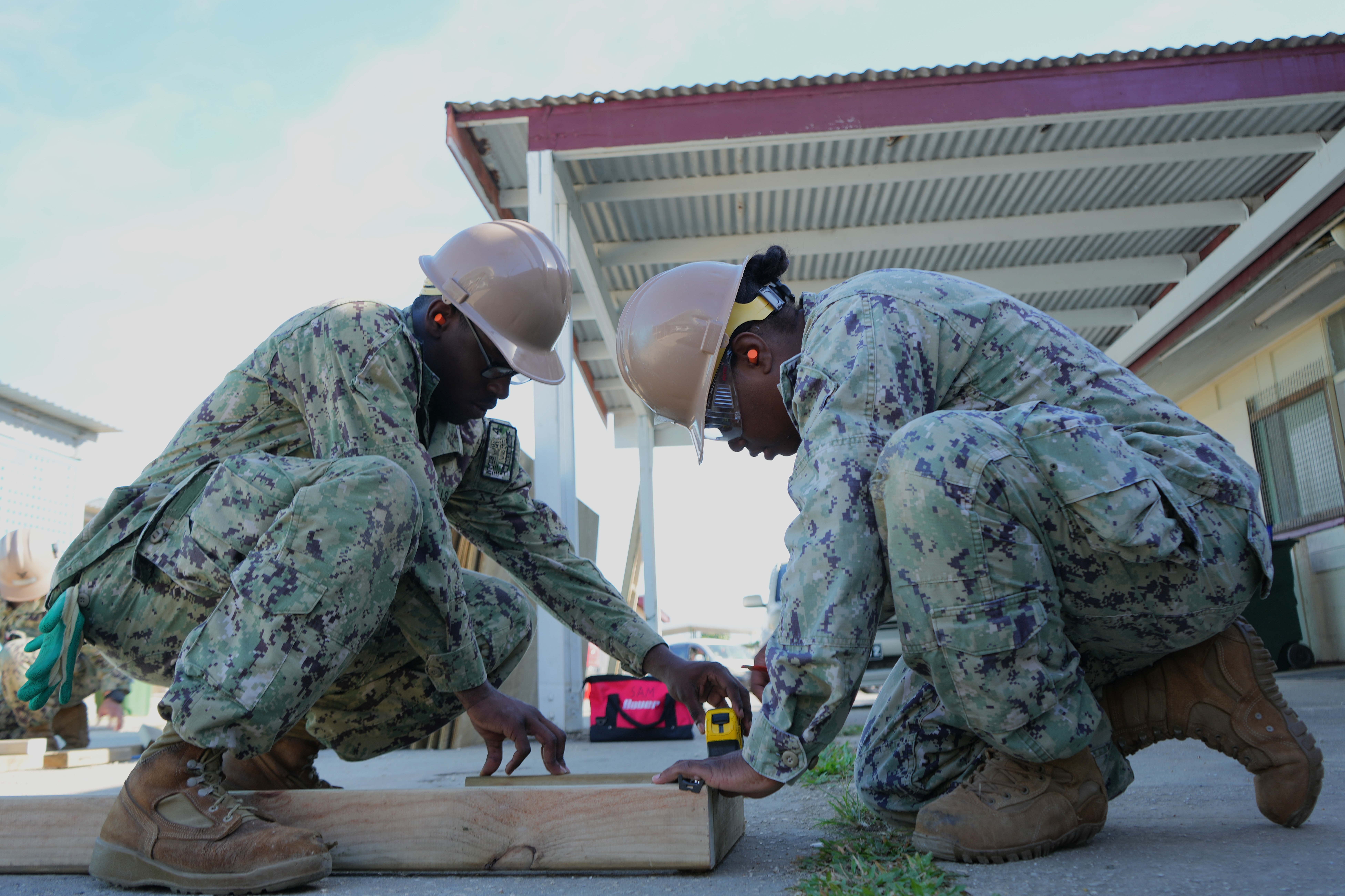 Builder 2nd Class Tivonja Johnson, right, and Builder Constructionman Keandre Gilbert, both assigned to Naval Mobile Construction Battalion 4, create lumber cut measurements during facility renovations at Vaiola Hospital as part of PP-25 in Nuku’Alofa, Tonga, June 21, 2025.